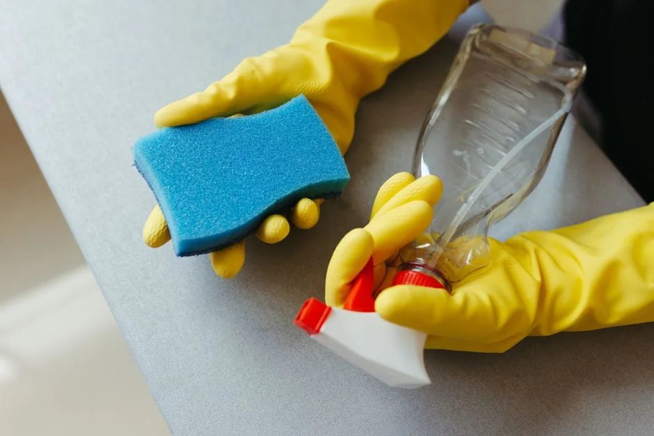 home-img A man indoors cleaning a glass door with a spray bottle and cloth.